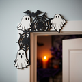 Halloween spider web corner decoration mounted on top of white interior door frame with moody Halloween home decor